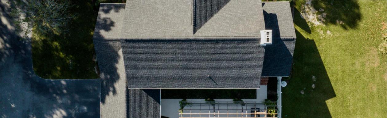 Service Areas Page Hero Image | Aerial View of Home With Architectural Asphalt Shingles | Onyx Black | Evans County Residental Roofers | Residential Roofing